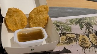 Dua potong ayam McNugget yang dilumuri saus asam manis