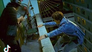 Jackie Chan jump off a tall building along the path of an air conditioner.