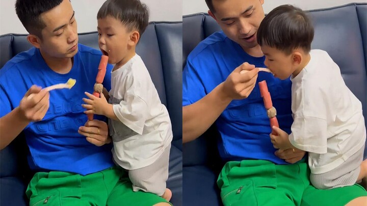 爸爸用香肠诱惑儿子给他喂饭，一碗饭下去儿子一口香肠都没吃着