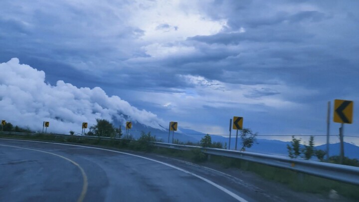 Going down Curved highway through a mountain range