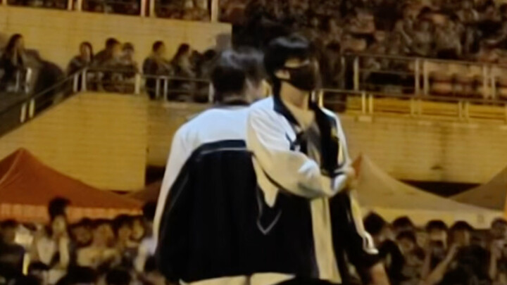 Military training performance, back shot of male college students dancing on the playground