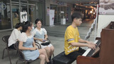 A girl watching the piano performance in the streets