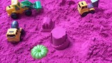 Saya menggunakan mainan kendaraan konstruksi untuk mengangkut pasir dan tanah dan meletakkannya di h