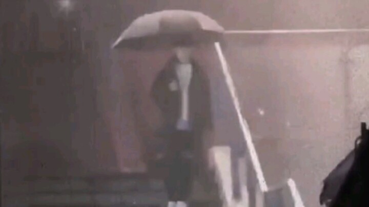 Yang Bao sedang memegang payung sendirian di tengah hujan, mabuk dan bertingkah genit serta menelepo