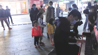 A boy playing the theme song of Dragon Ball on the street