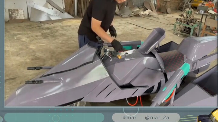 Japanese girl looks at handmade "homemade fighter-style water fight motorcycle"