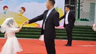 At the kindergarten’s Children’s Day performance, the father wore a suit and danced the waltz with h