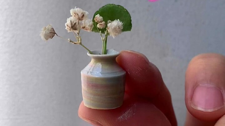 Made of mini pottery at fingertips, a small flower in a small ceramic vase looks very cute and beaut