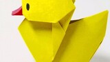 Bebek kuning kecil origami, yang dikatakan membawa keberuntungan, dilipat dan diletakkan di atas mej